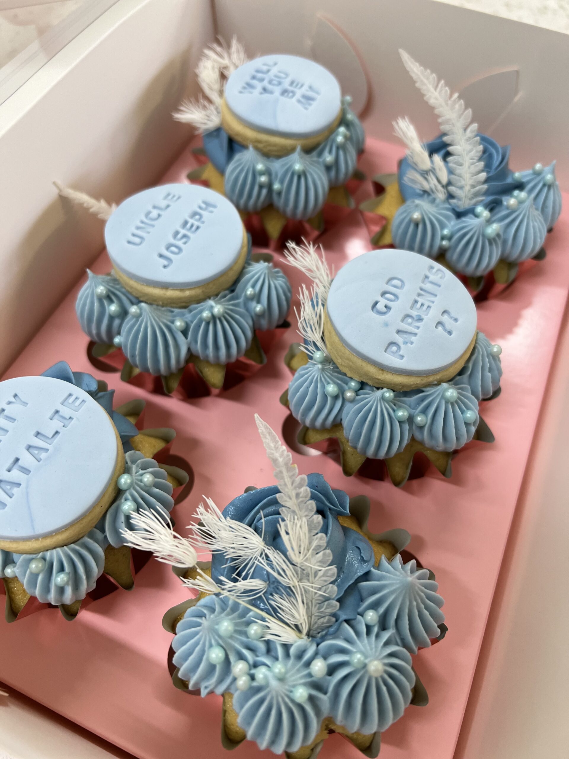 Custom blue buttercream cupcakes with personalised fondant toppers for baptism celebrations, handcrafted in Ayr.