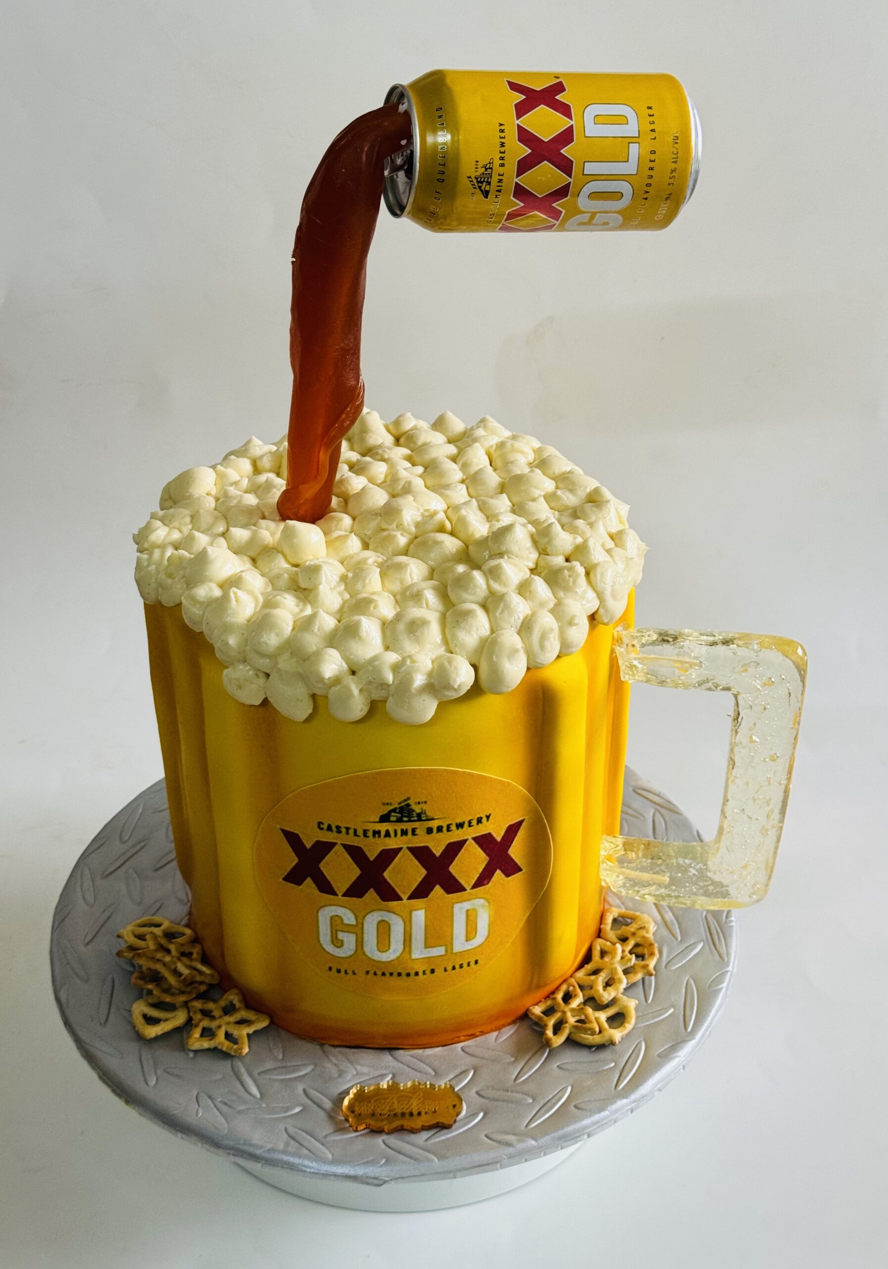 Novelty XXXX Gold beer mug cake with buttercream foam detailing and realistic pouring effect, custom celebration cake in Ayr.