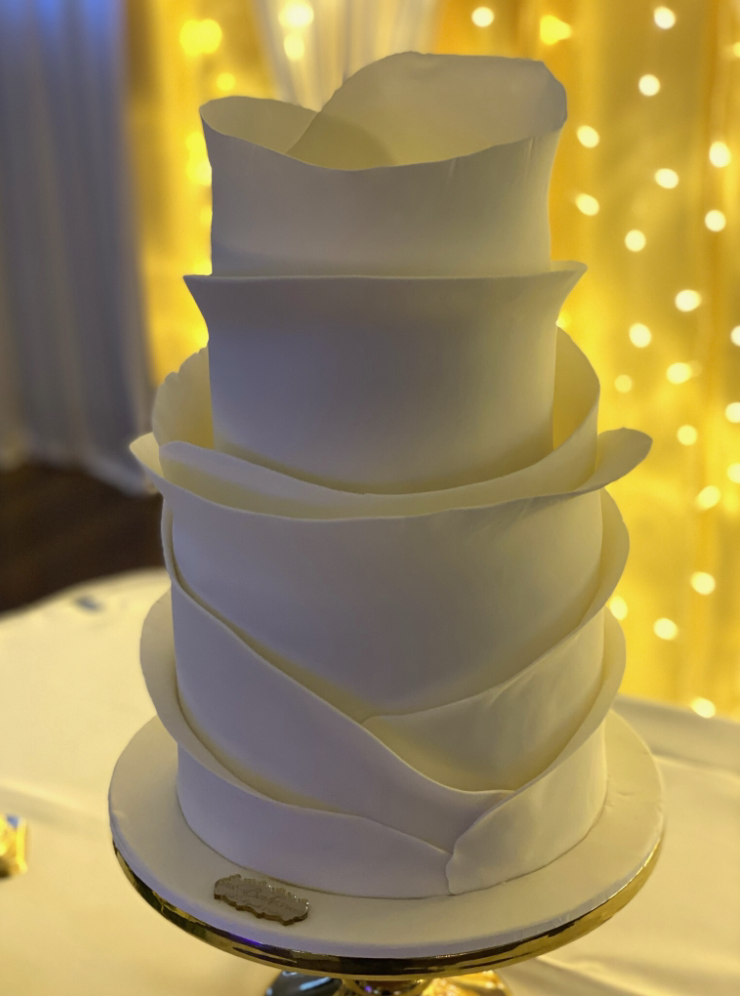Modern white buttercream wedding cake with sculpted wrap-around texture, handcrafted for elegant celebrations in Ayr.