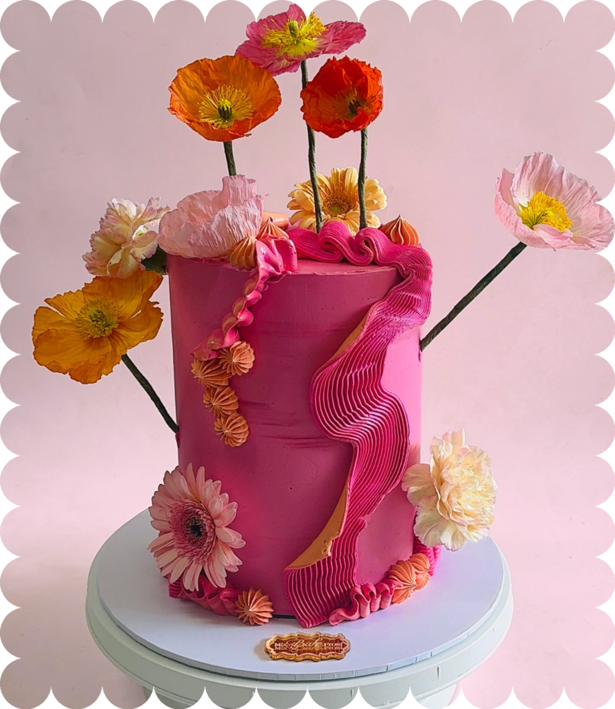 Bespoke pink buttercream cake with textured piping and fresh florals, handcrafted for a special celebration.